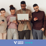 People standing next to each other looking at their devices